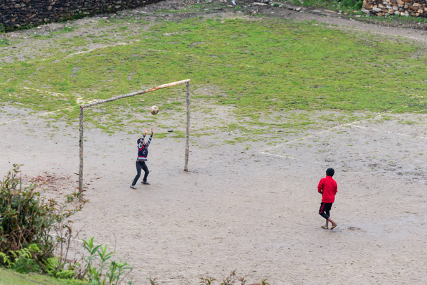 GHALEGAUN, NEPAL - CIRCA MAY 2018: chidren play football. The goal is made of tree branches. - Photo, image
