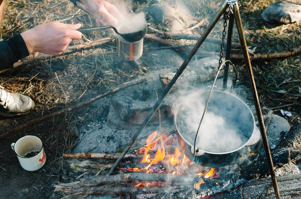 an old way of preparing food above a simple wood fire. - Zdjęcie, obraz