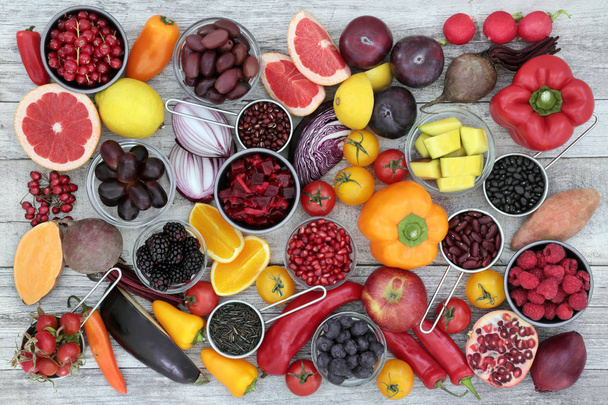 Concepto de alimentación saludable para fitness con frutas, verduras, granos y legumbres ricos en antocianinas, antioxidantes, vitaminas y minerales sobre madera rústica
. - Foto, Imagen