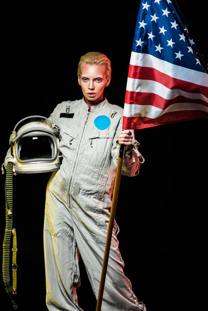 belo cosmonauta fêmea em capacete segurando espaço e bandeira dos EUA, isolado em preto
 - Foto, Imagem