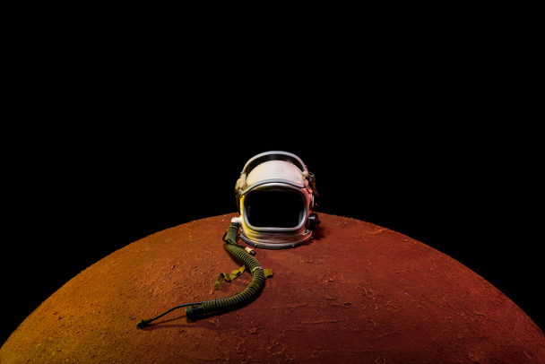 capacete do traje espacial deitado no planeta Mars no universo negro
 - Foto, Imagem