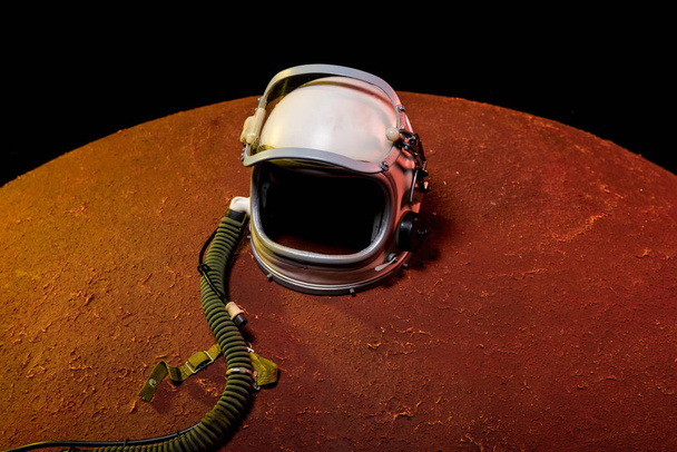 Helm aus Raumanzug liegt auf rotem Planeten im schwarzen Kosmos - Foto, Bild