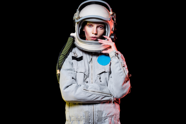 attractive female astronaut in spacesuit and helmet isolated on black - Photo, Image