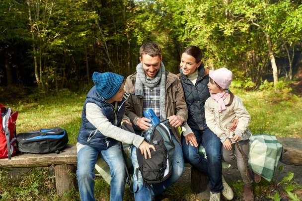 happy family with backpacks and thermos at camp - Photo, image