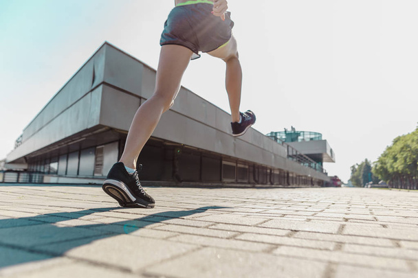 Pretty sporty woman jogging at city - Foto, Imagem