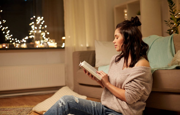 happy young woman reading book at home - Foto, Imagem