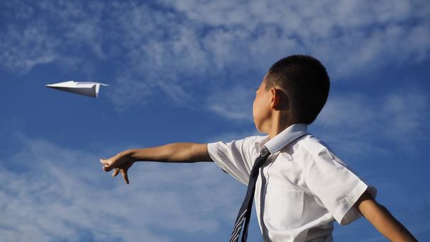 Un écolier asiatique pilotant un avion en papier. (Objet sélectionné
) - Photo, image
