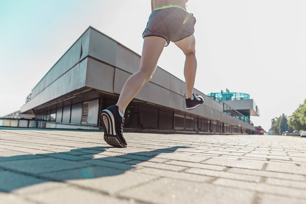 Pretty sporty woman jogging at city - Фото, изображение