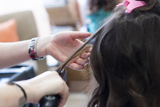 Redresser les cheveux avec du fer à repasser chaud sur un salon professionnel
. - Photo, image