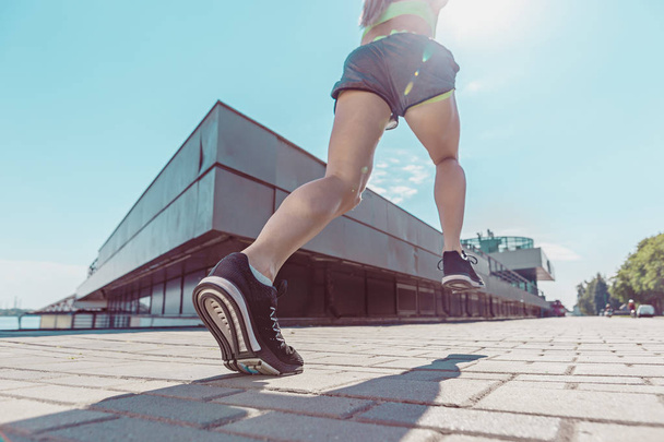 Pretty sporty woman jogging at city - Fotoğraf, Görsel