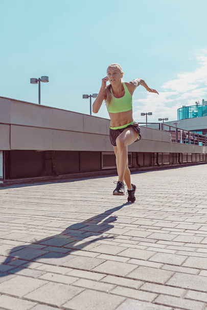 Pretty sporty woman jogging at city - Φωτογραφία, εικόνα