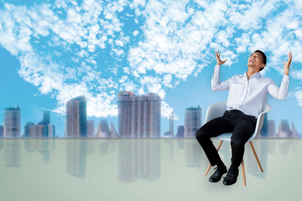 Kariéra obchodní muž sezení křesla vyjádřit pocit v místnosti města rozmazané pozadí oblohy metafora pro finanční úspěch jednání kupní nebo pojištění obraz - Fotografie, Obrázek
