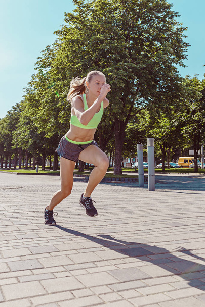 Pretty sporty woman jogging at city - 写真・画像