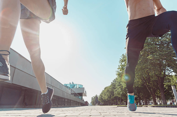 Pretty sporty woman and man jogging at city - Fotó, kép