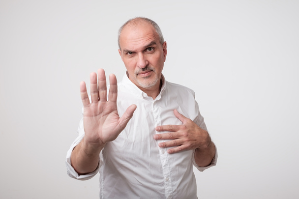 Starší muž v bílé košili, ukazující znamení zastavit rukou. Odepřít něco udělat - Fotografie, Obrázek