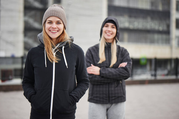 two friends in stylish sportswear posing at street  - Photo, Image