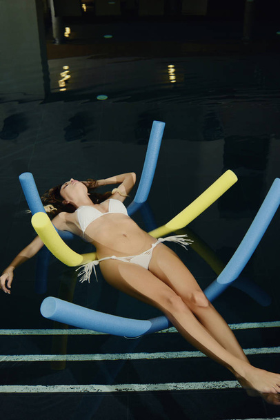 beautiful woman floating in the water in spa pool - Foto, afbeelding