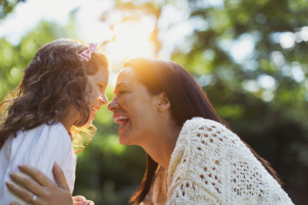 Энтузиастичные мать и дочь улыбаются лицом к лицу
 - Фото, изображение
