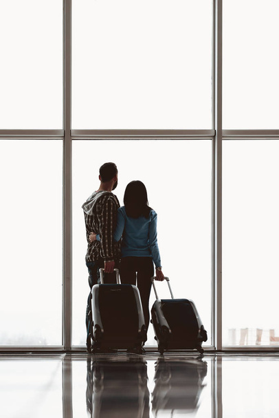 Back view.Young couple with suitcases - Photo, Image