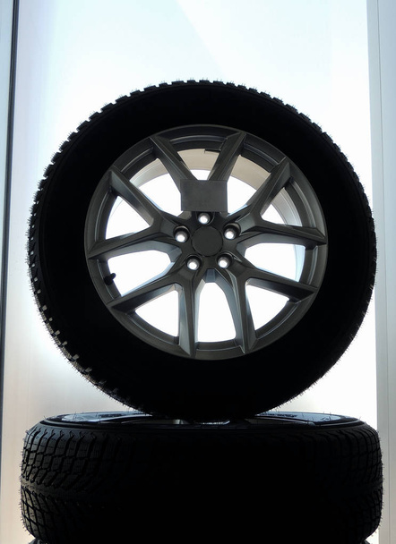 Стойка сборных колес с новыми шинами и дисками из сплава изолирована
  - Фото, изображение