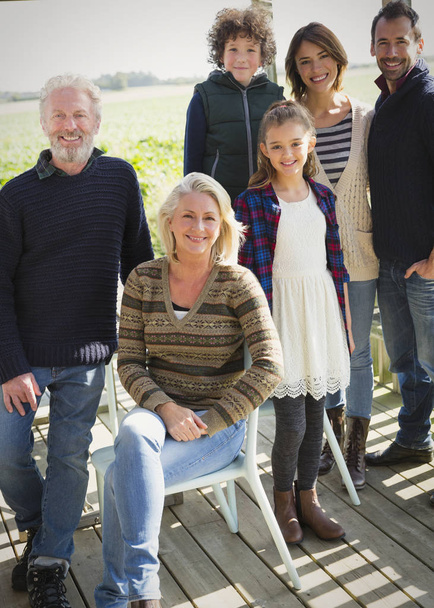 Retrato sonriente familia multi-generación en el porche
 - Foto, imagen