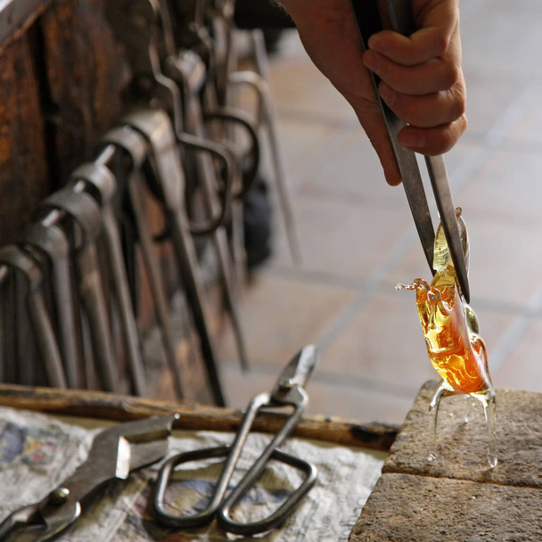 Скляний художник у своїй майстерні робить скляний посуд
 - Фото, зображення
