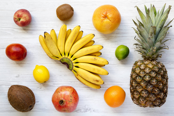 Set of fresh tropical fruits on a white wooden background, from above. Top view. Flat lay. - Foto, Bild