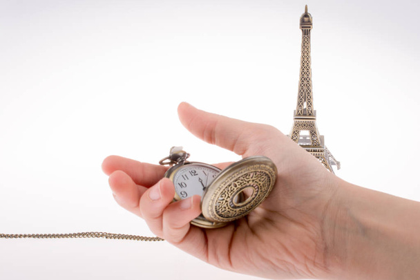 Hand holding a pocket watch befere Eifel Tower - Fotó, kép