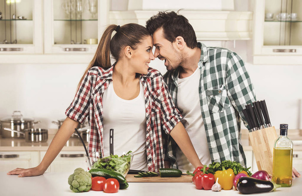 Husband and wife look at each other in kitchen. - Φωτογραφία, εικόνα