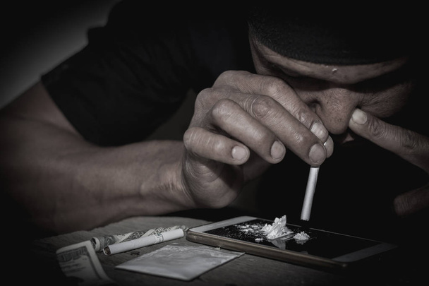  Los hombres consumen drogas, el concepto de crimen y adicción a las drogas. 26 de junio, Día Internacional contra el Abuso de Drogas y el Tráfico Ilícito
 - Foto, imagen