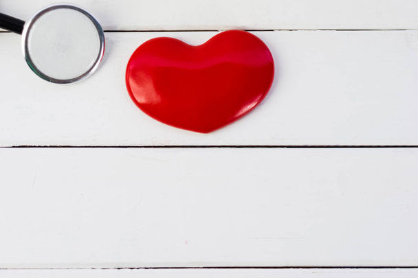 Corazón rojo y estetoscopio en mesa marrón, día mundial de la salud y concepto de salud
. - Foto, imagen