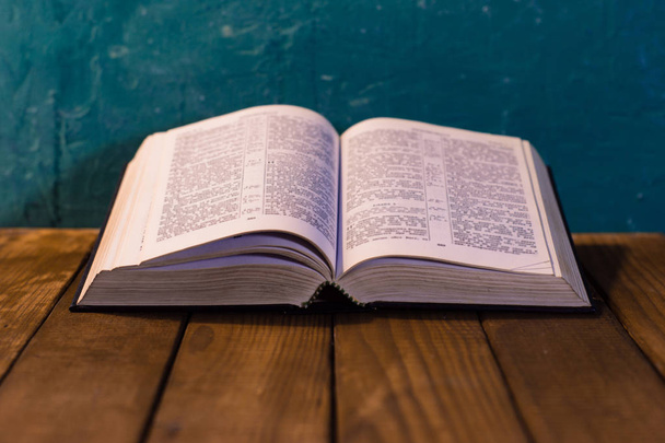 Ανοίξτε την Αγία Γραφή σε ένα παλιό τραπέζι. Όμορφο φόντο. Έννοια της θρησκείας. - Φωτογραφία, εικόνα