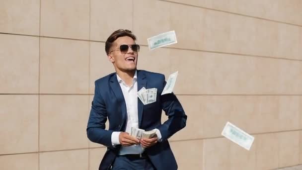 Young happy businessman dancing and throwing money. Slow motion. Successful business or winning the lottery - Video
