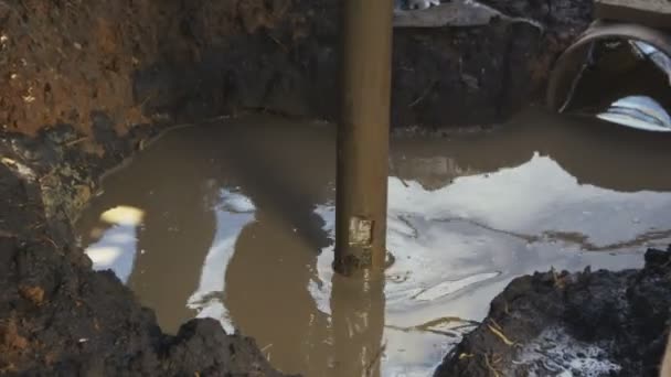Prospección de tuberías de metal Pit da la vuelta en el suelo de barro
 - Metraje, vídeo