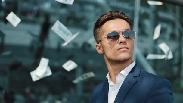 Falling dollars on the young happy businessman. Money rain. Business, people and finances concept - Materiał filmowy, wideo