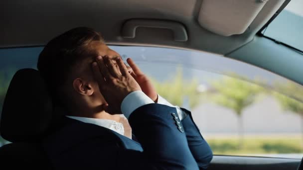 Unavené a namáhané podnikatel sedí v autě. Muž s bolestí hlavy. Stres, bankrot, špatné zprávy, bolest - Záběry, video