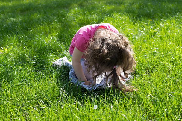 Little girl playing at the green lawn - Fotó, kép