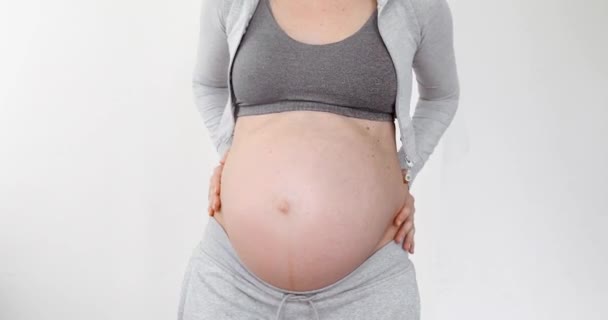 Mujer embarazada tocándose el vientre con las manos - Imágenes, Vídeo