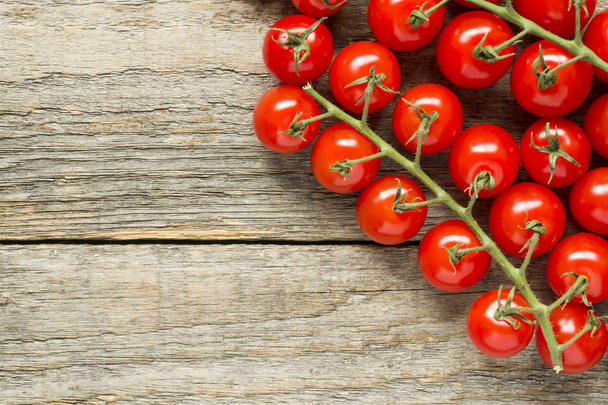 Cherry tomato on a branch on a wooden rustic copy space background. - Foto, imagen