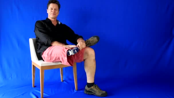 Knappe man, gehandicapten en onbevangen, gaat en zit in de stoel, opent zijn armen, draait en ondersteunt de prothese en laat glimlachen. Meer opties In mijn portefeuille - Video