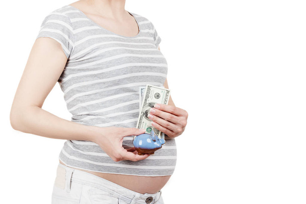 Pregnant woman with dollars and a piggy bank in the hands, isolated - Foto, afbeelding