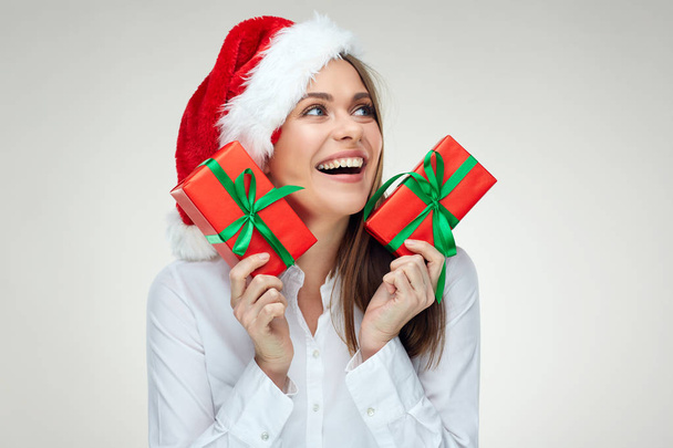 surprised woman in Santa hat and white shirt holding red gift boxes, Christmas concept  - Φωτογραφία, εικόνα