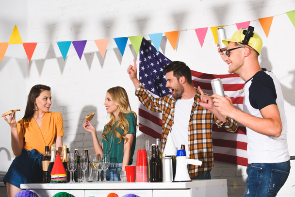 szczęśliwy młodych przyjaciół jeść przekąski i picie alkoholu podczas zabawy razem w domu party - Zdjęcie, obraz