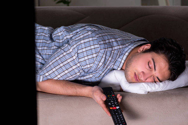 Jeune homme regardant la télévision tard dans la nuit - Photo, image
