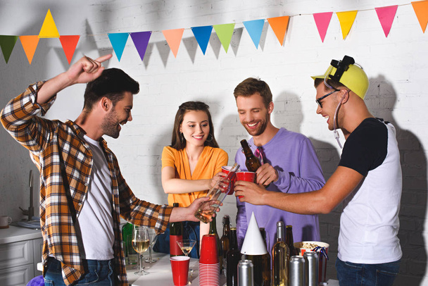 happy young friends drinking alcohol while partying together - Foto, imagen