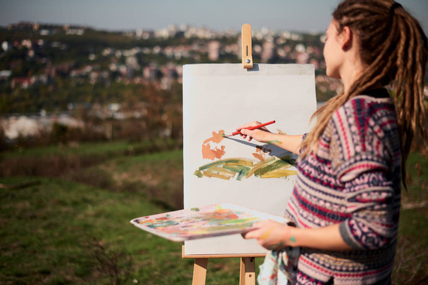 Chica artística pintura sobre lienzo en caballete al aire libre
 - Foto, Imagen