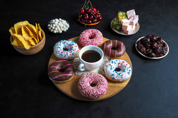 Doces de rosquinha e doces turcos em uma mesa preta com espaço de cópia
 - Foto, Imagem