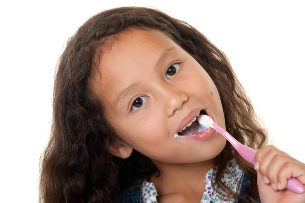 Menina bonito limpa os dentes, criança com escova de dentes contra fundo branco
 - Foto, Imagem