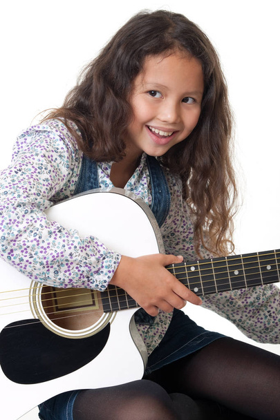Dziewczyna gra na gitarze, portret dziecka z instrumentu muzycznego przed białym tle - Zdjęcie, obraz