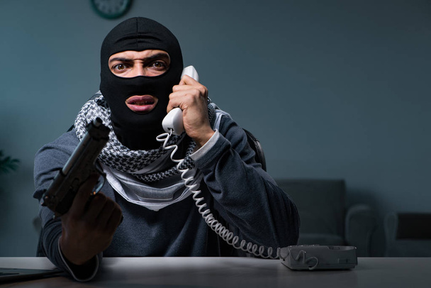 Terrorysta włamywacz z bronią pracujący przy komputerze - Zdjęcie, obraz
